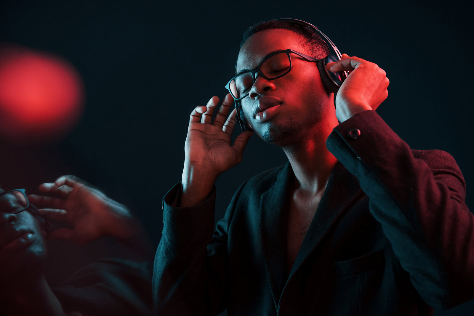 Musicien afro-americain au casque, immergé dans sa création sous une lumière néon