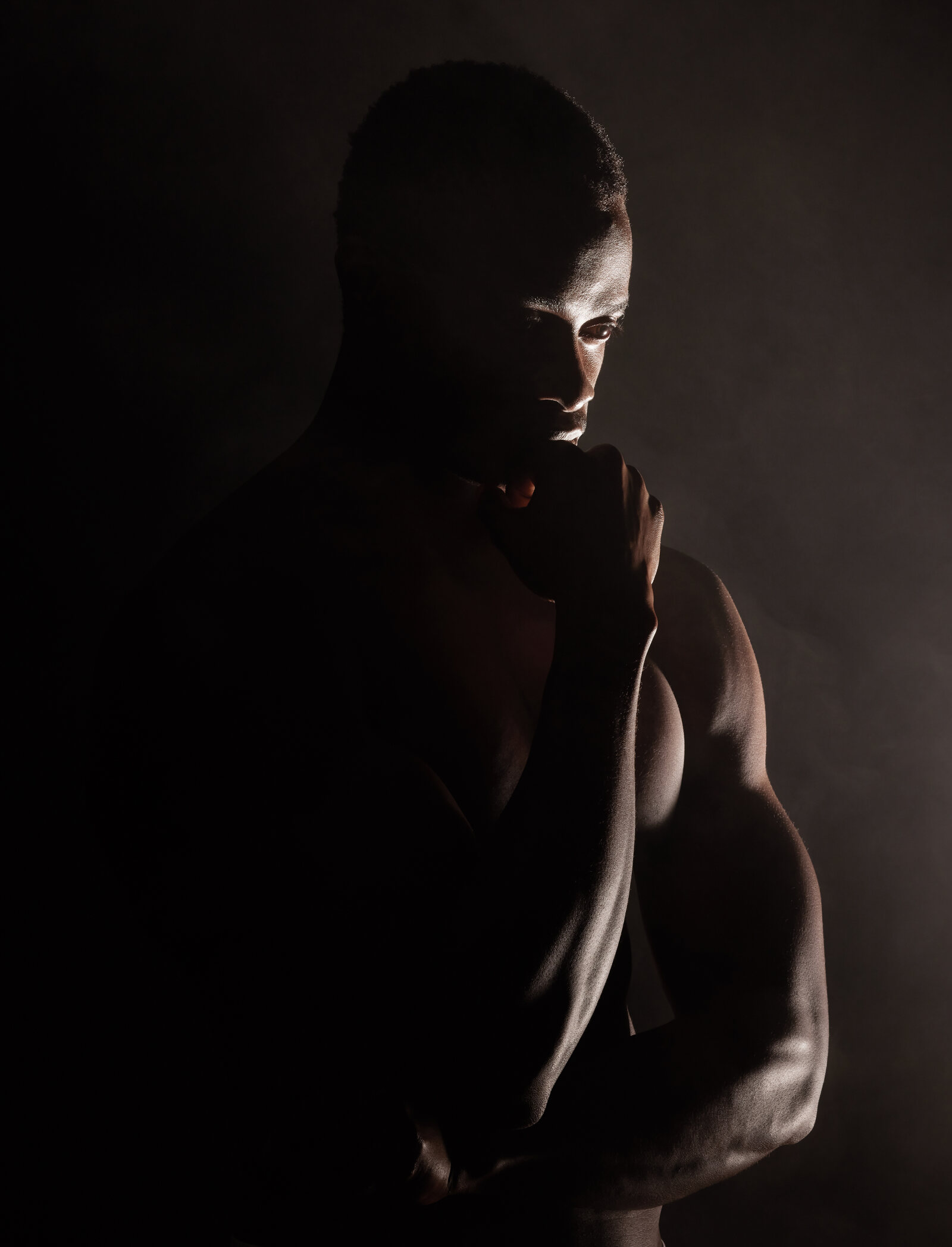 Homme afro-americain musclé dans une lumière dramatique, un corps construit par un cadre